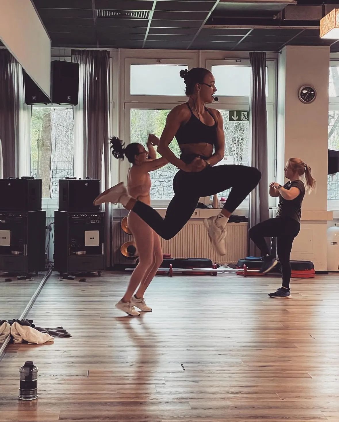 Laura leitet einen Group-Fitness-Kurs mit Headset.