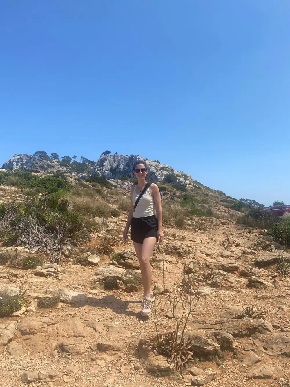 Chrissi hiking on the Mallorca cliffs, quiet and composed