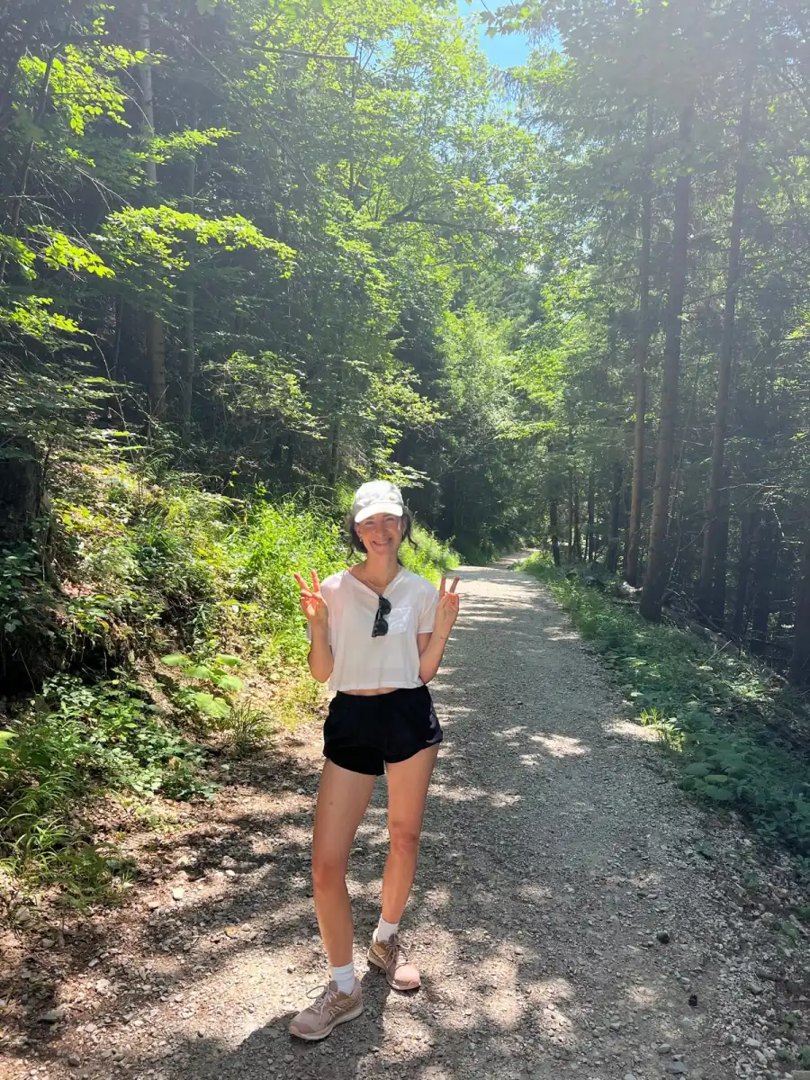 Chrissi on a forest path, sunlight through the trees